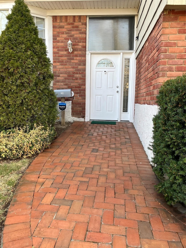 view of exterior entry with brick siding