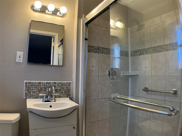 full bathroom featuring vanity, a shower stall, toilet, and backsplash