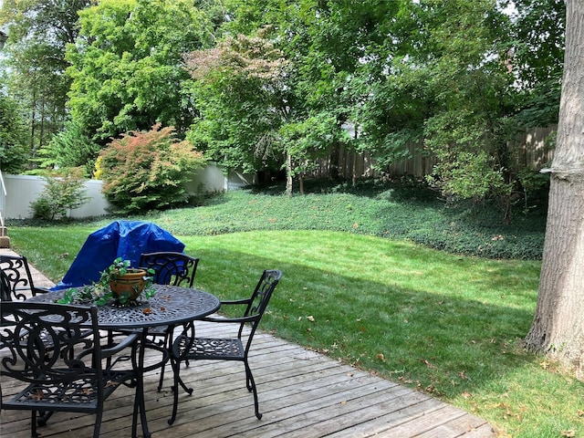 view of yard featuring a deck, outdoor dining area, and fence