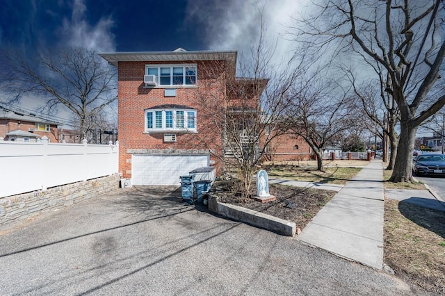 3125 Spencer Dr, Bronx, NY 10465 - view of home's exterior featuring an attached garage, aphalt driveway, fence, and brick siding