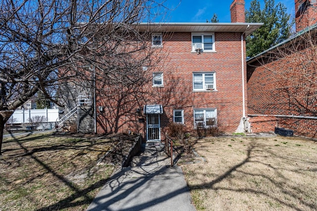 3125 Spencer Dr, Bronx, NY 10465 - rear view of house with a chimney, brick siding, and a yard