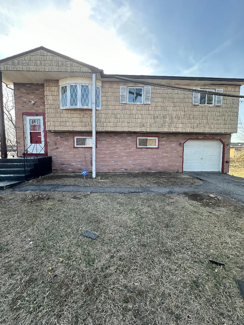 view of property exterior featuring a garage, brick siding, and aphalt driveway