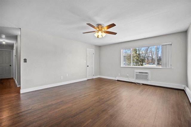 spare room featuring a wall mounted air conditioner, baseboards, dark wood-style flooring, and a ceiling fan