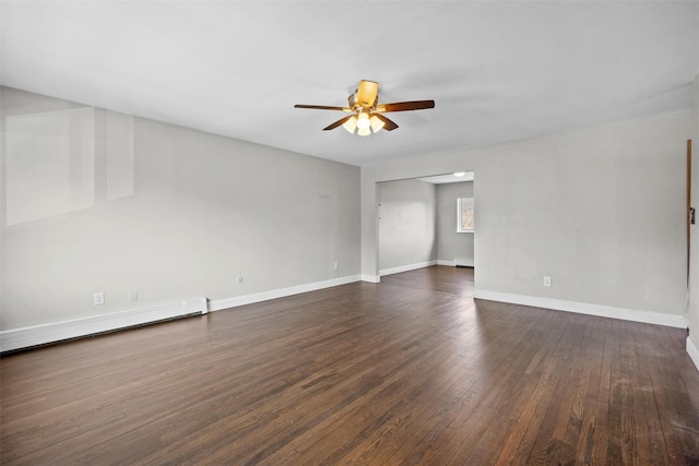 unfurnished room featuring a baseboard heating unit, a ceiling fan, dark wood finished floors, and baseboards