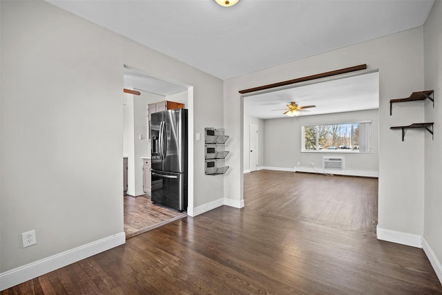 unfurnished living room featuring ceiling fan, baseboards, dark wood finished floors, and a wall mounted AC