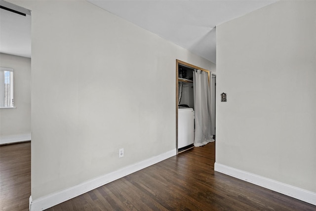 unfurnished room with baseboards, washer / clothes dryer, and dark wood-style flooring