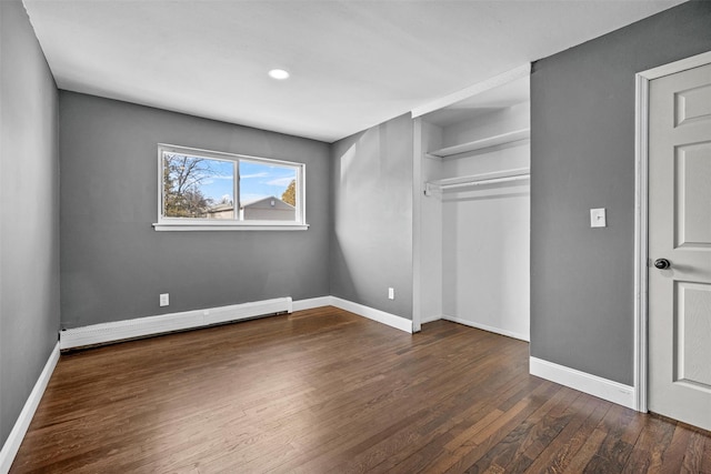 unfurnished bedroom with dark wood-style floors, a closet, baseboards, and a baseboard radiator