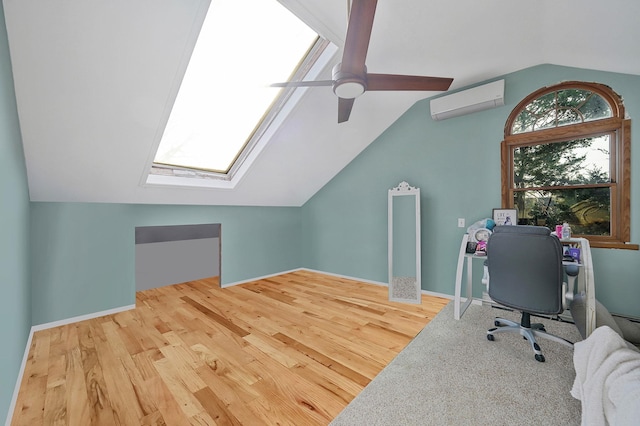 office space with a ceiling fan, wood finished floors, baseboards, an AC wall unit, and vaulted ceiling