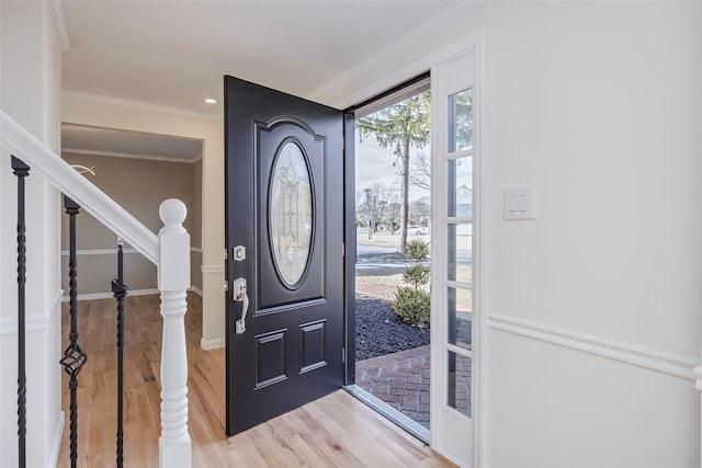 entryway with stairway, baseboards, light wood finished floors, and ornamental molding