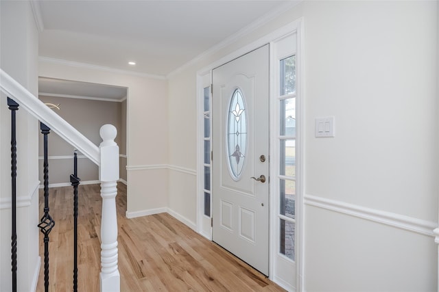 foyer entrance featuring light wood finished floors, stairs, baseboards, and ornamental molding