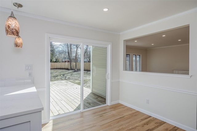 doorway with recessed lighting, baseboards, ornamental molding, and light wood finished floors