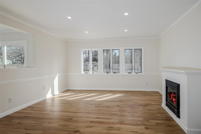 unfurnished living room featuring a glass covered fireplace, light wood-style flooring, and plenty of natural light