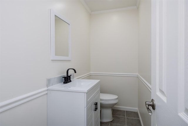 half bathroom with toilet, ornamental molding, vanity, and tile patterned flooring