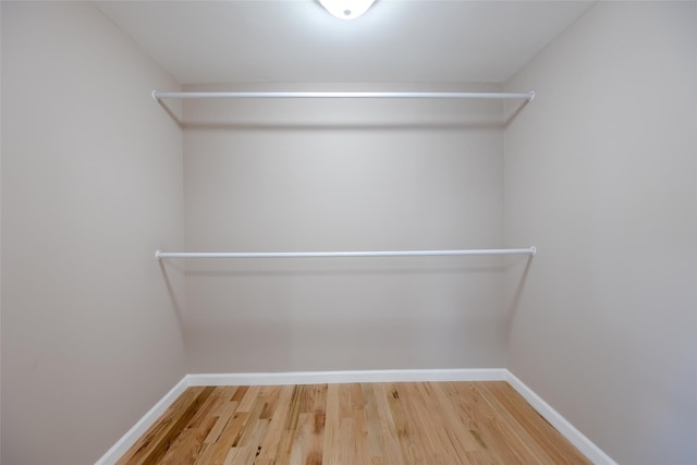 walk in closet with wood finished floors