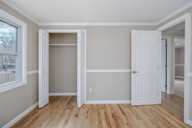 unfurnished bedroom featuring baseboards, light wood-type flooring, a closet, and ornamental molding