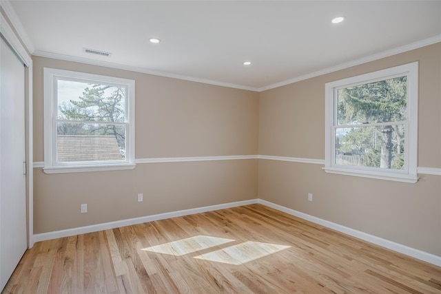 unfurnished room with visible vents, baseboards, wood finished floors, and crown molding