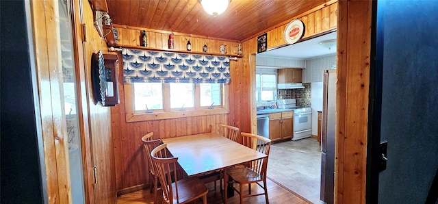 dining area featuring wooden walls and wood ceiling