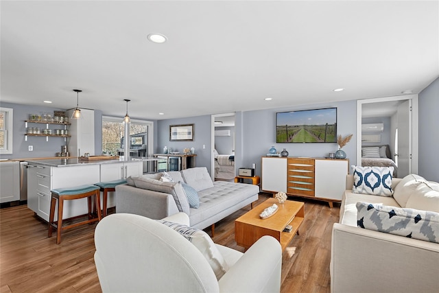 living room with wet bar, recessed lighting, and light wood-style floors