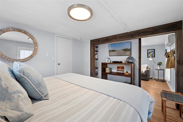 bedroom featuring an AC wall unit and wood finished floors