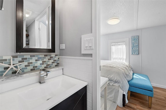 ensuite bathroom with vanity, a textured ceiling, ensuite bathroom, and wood finished floors