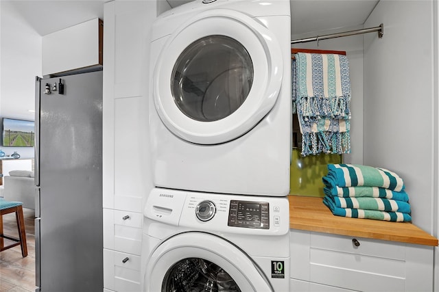 clothes washing area with laundry area and stacked washing maching and dryer