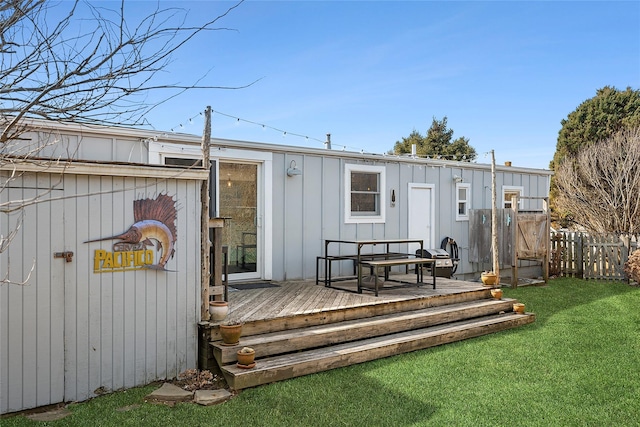 back of house featuring a yard, a wooden deck, and fence