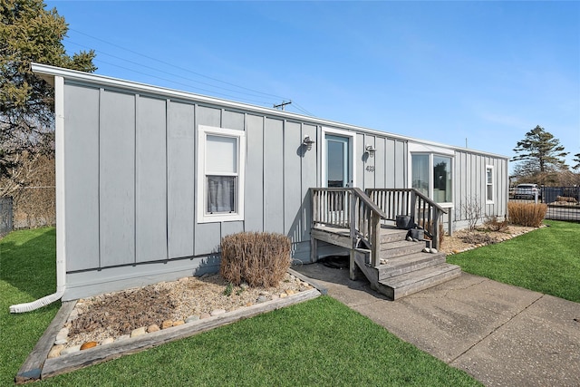 view of front of property featuring a front lawn, fence, and board and batten siding