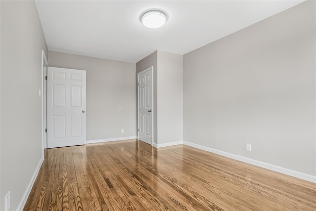 unfurnished bedroom with wood finished floors and baseboards