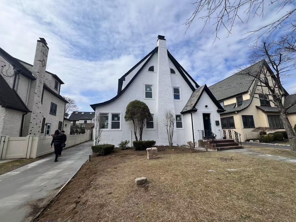 view of front of house with stucco siding and fence