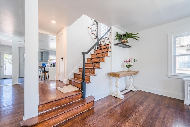 stairs featuring plenty of natural light, baseboards, and hardwood / wood-style flooring
