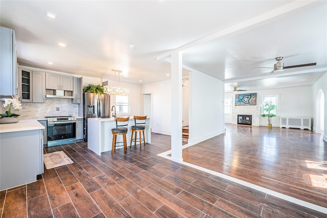 kitchen featuring tasteful backsplash, stainless steel electric stove, open floor plan, radiator heating unit, and gray cabinets
