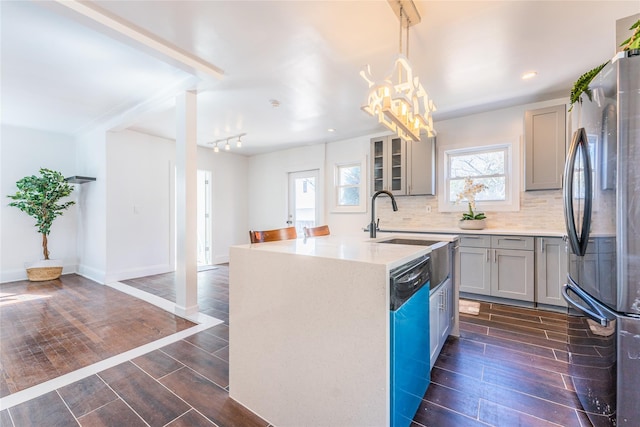 kitchen with wood tiled floor, dishwasher, gray cabinets, and freestanding refrigerator