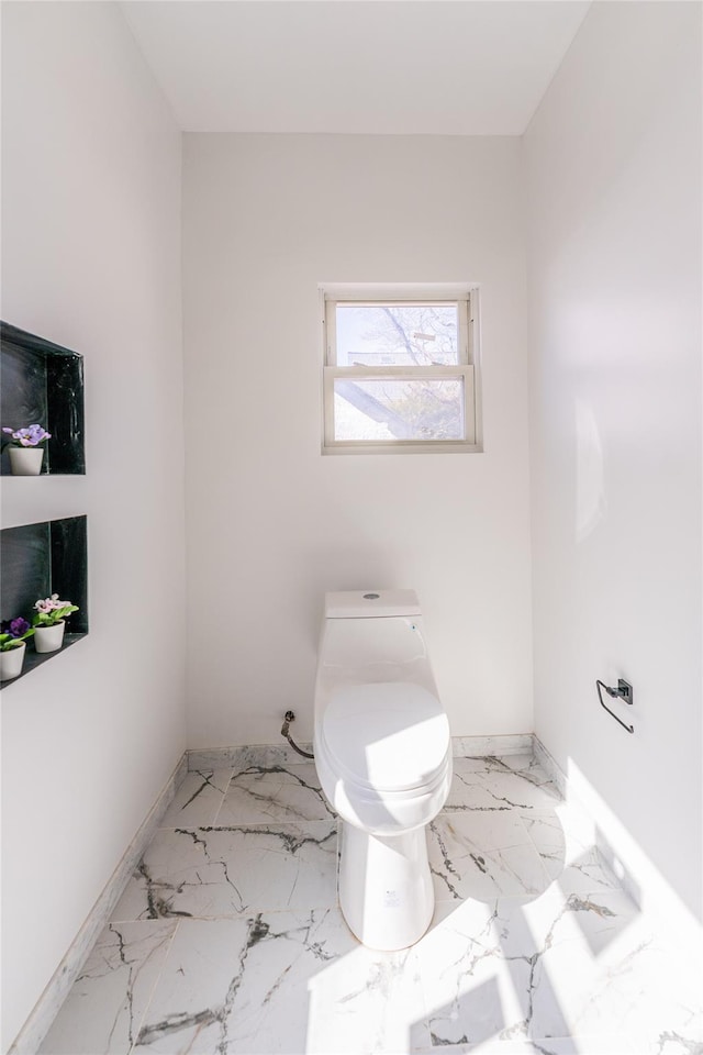 bathroom with toilet and baseboards