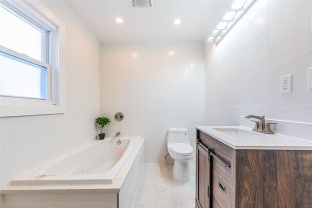 full bathroom with a tub with jets, toilet, tile walls, and vanity