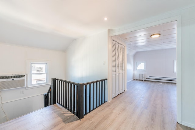 hall featuring radiator, lofted ceiling, light wood-style flooring, a baseboard heating unit, and an upstairs landing