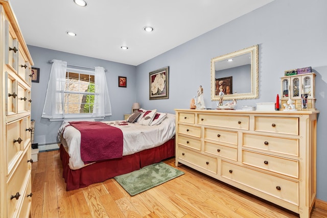 bedroom featuring a baseboard heating unit, recessed lighting, and light wood-type flooring