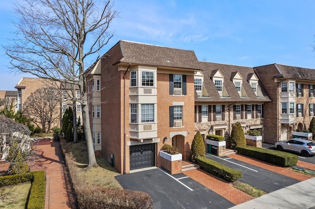 view of building exterior with aphalt driveway and a garage