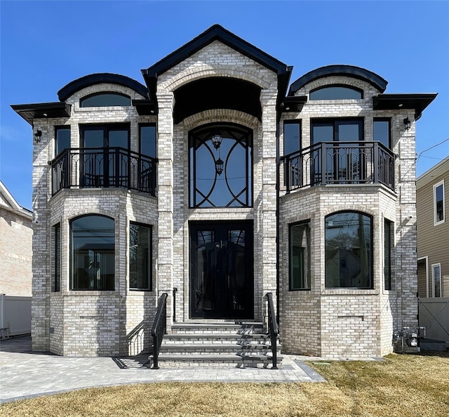 exterior space with brick siding and a balcony