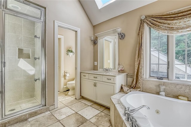 bathroom with a shower stall, lofted ceiling with skylight, toilet, a whirlpool tub, and vanity