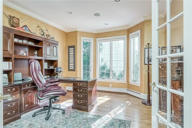 office area with a baseboard heating unit, crown molding, light wood-style floors, and baseboards