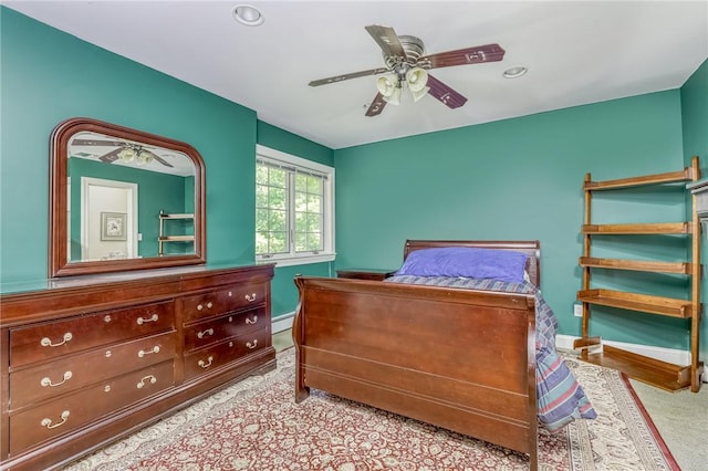 bedroom with ceiling fan, a baseboard heating unit, and baseboards