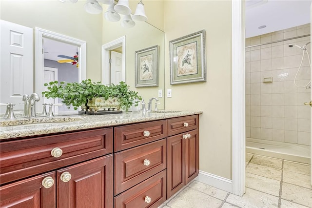 bathroom featuring a sink, baseboards, and a tile shower