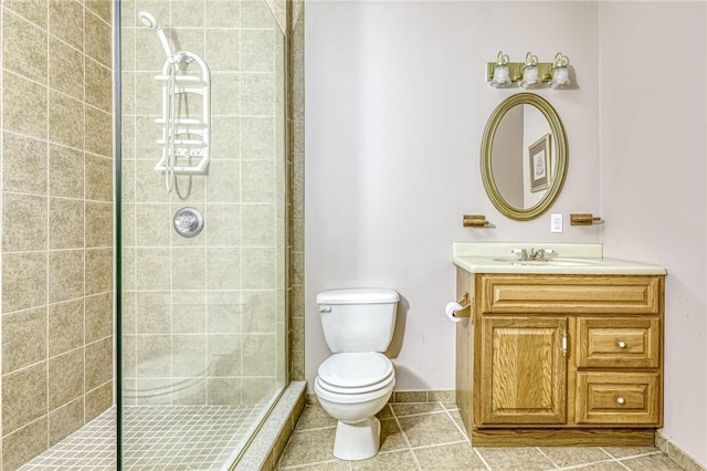 full bath featuring baseboards, toilet, a tile shower, tile patterned floors, and vanity