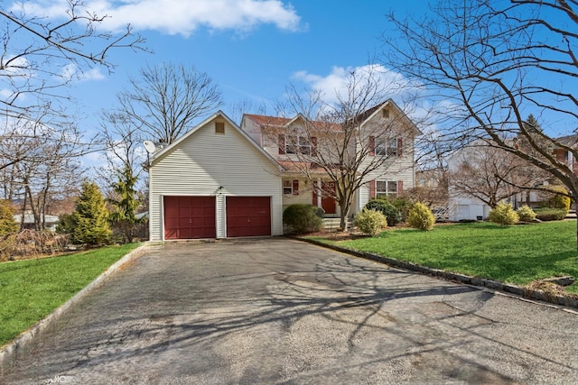 traditional-style house with aphalt driveway, a garage, and a front lawn