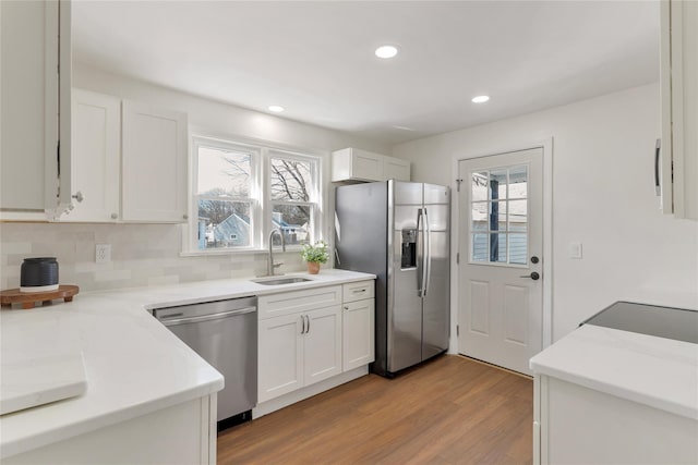 kitchen featuring a sink, wood finished floors, appliances with stainless steel finishes, and a wealth of natural light