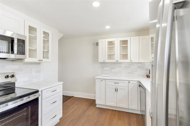 kitchen featuring baseboards, dark wood-style flooring, light countertops, white cabinets, and appliances with stainless steel finishes