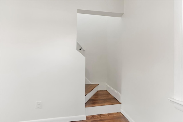 stairway featuring wood finished floors and baseboards