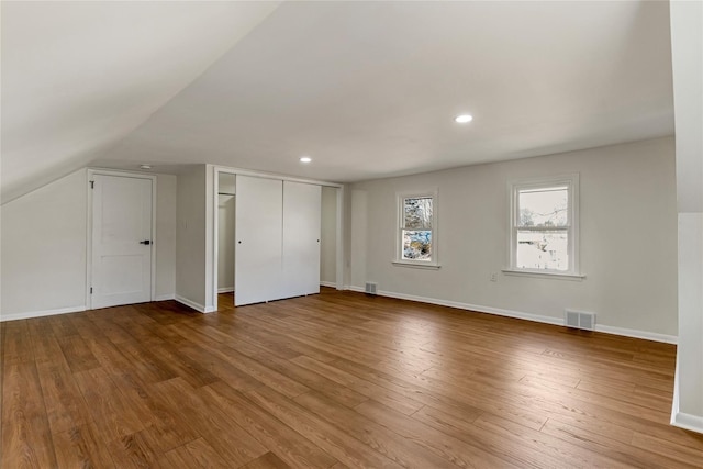 additional living space with recessed lighting, visible vents, baseboards, and wood finished floors