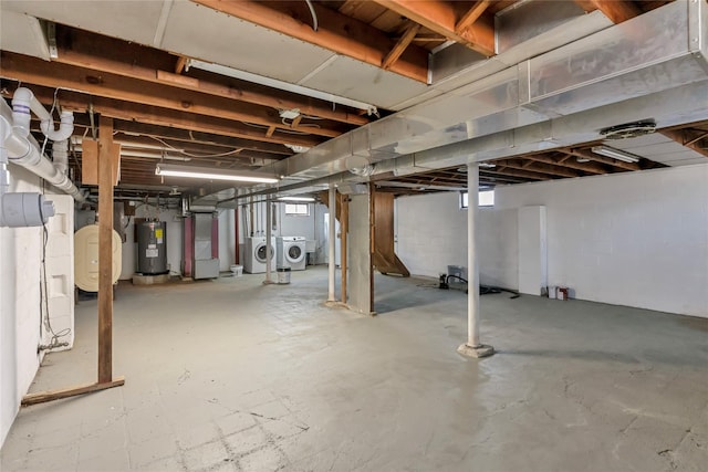 below grade area featuring washer and clothes dryer and electric water heater