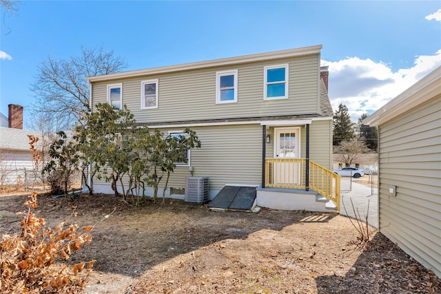 rear view of property with central AC and fence